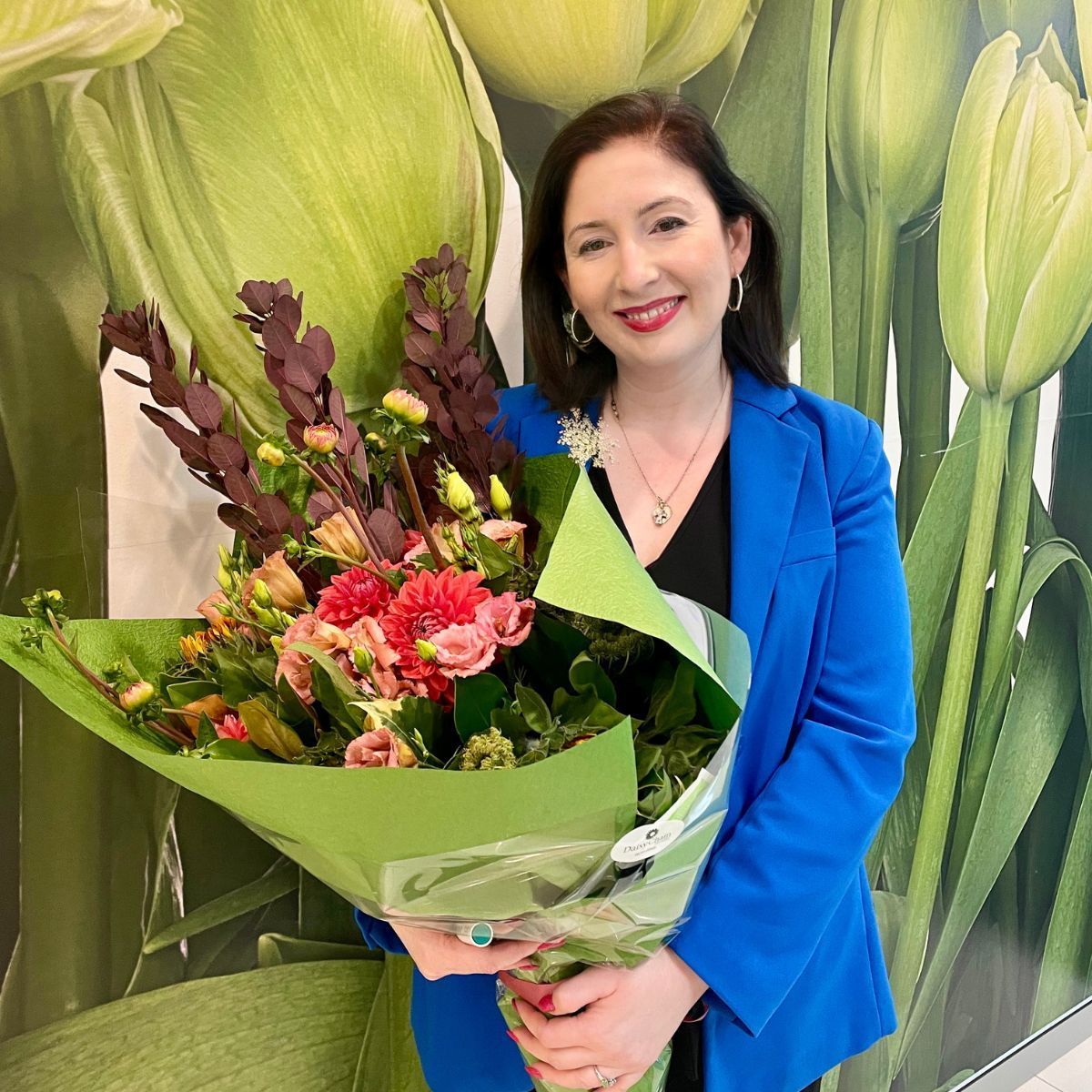 A group of people are standing in a room with their arms in the air.