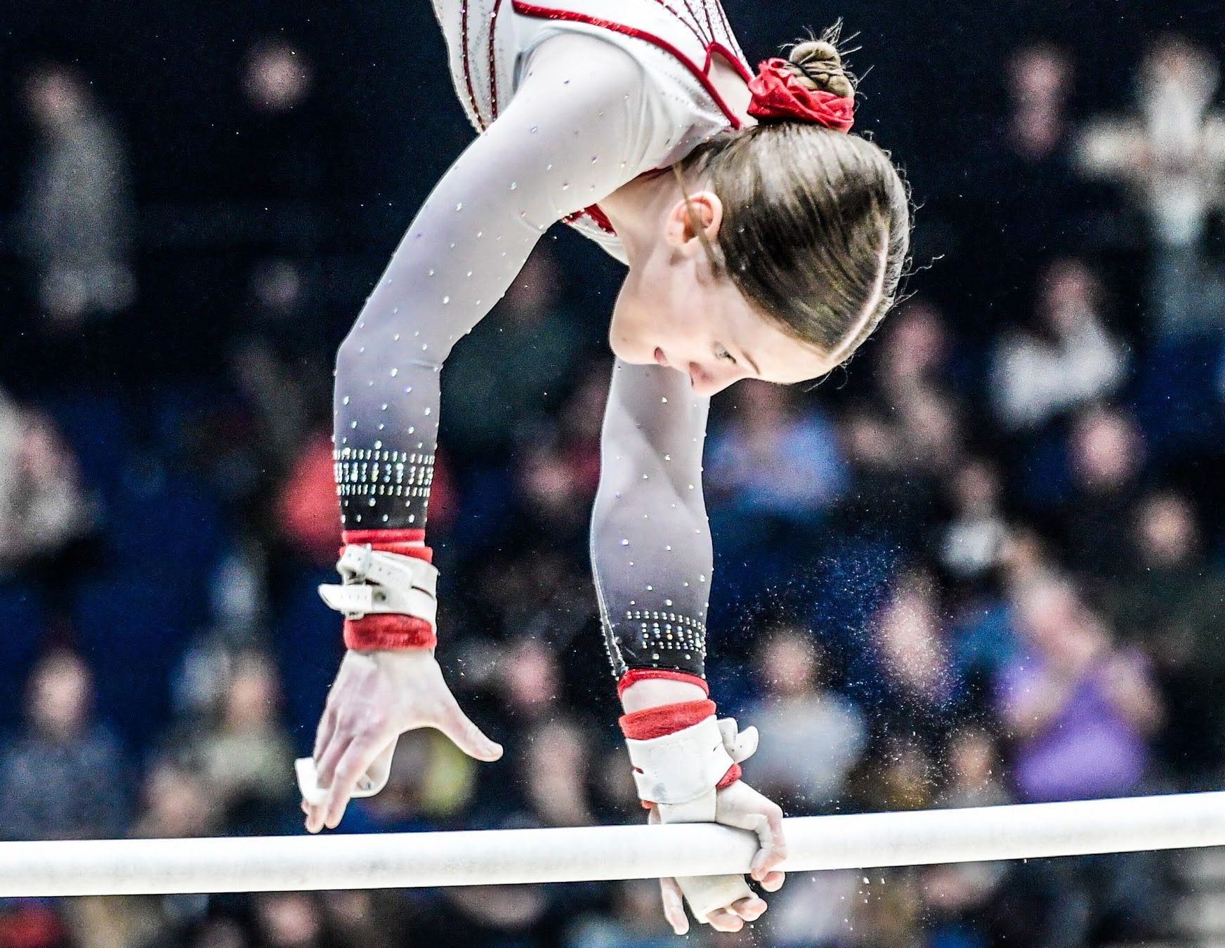 A female gymnast is doing a handstand on parallel bars