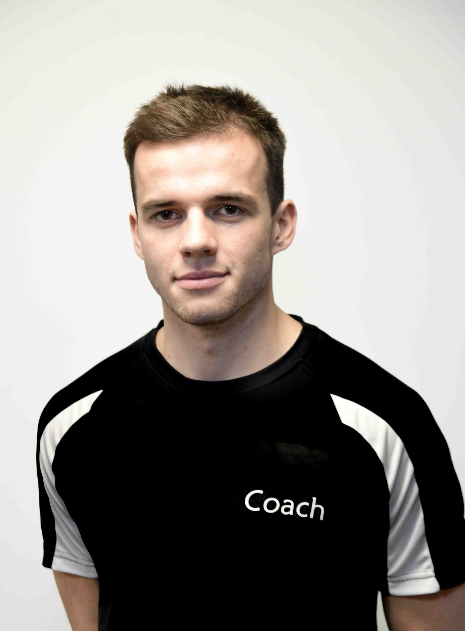 A man wearing a black shirt that says coach on it