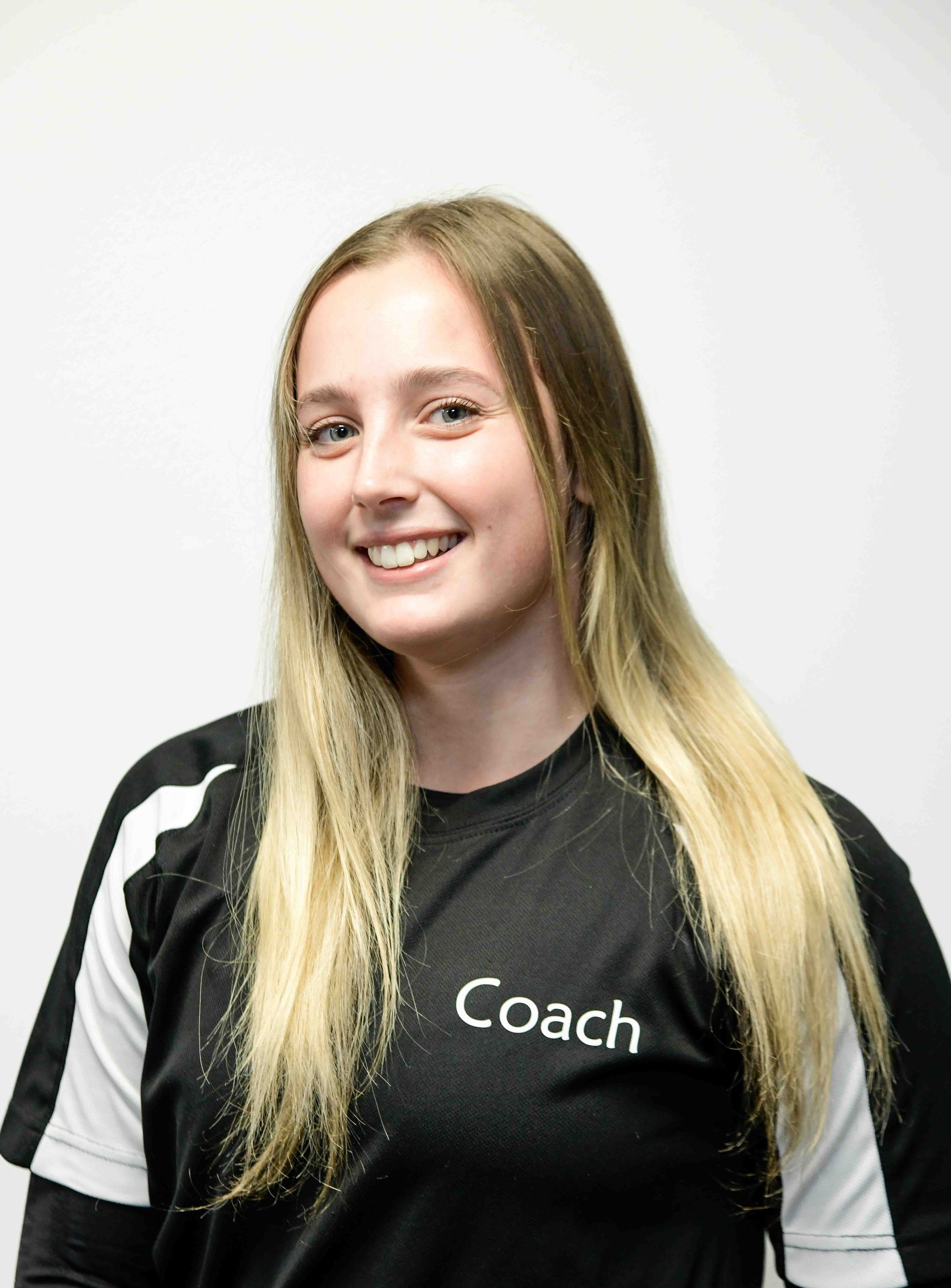 A woman wearing a black shirt with the word coach on it