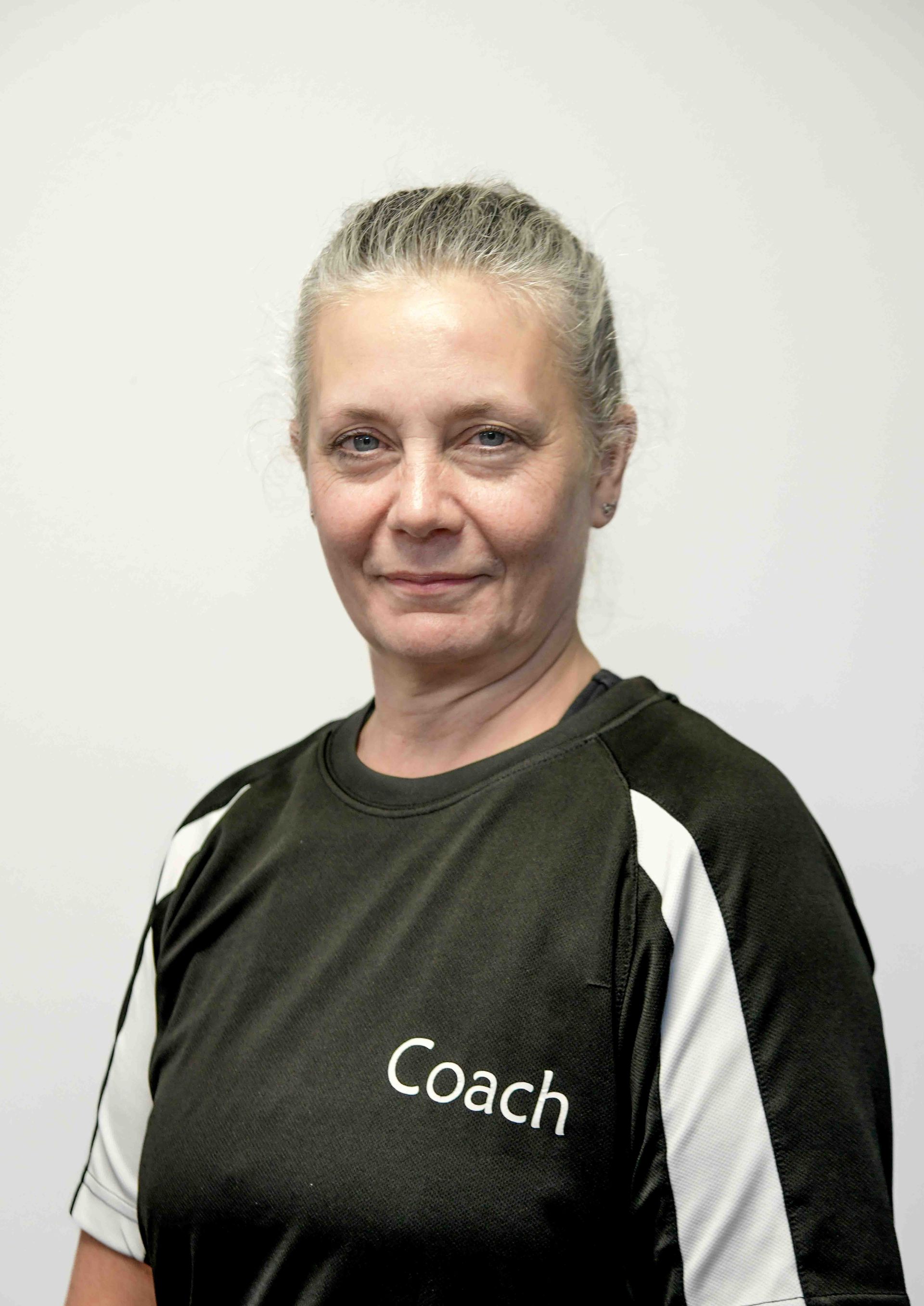 A woman wearing a black shirt that says coach on it