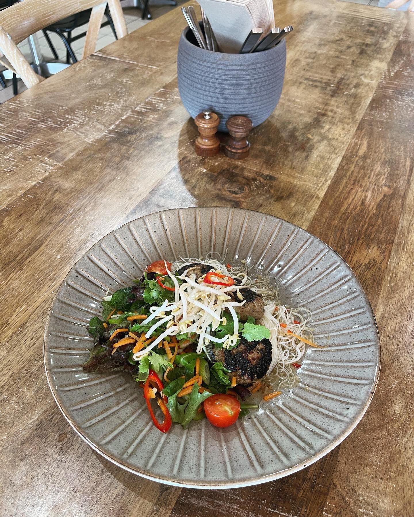 A plate of food is sitting on a wooden table.