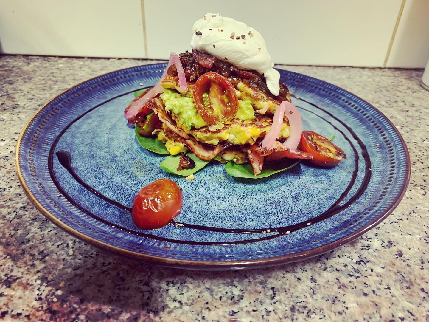 A blue plate topped with a salad and tomatoes