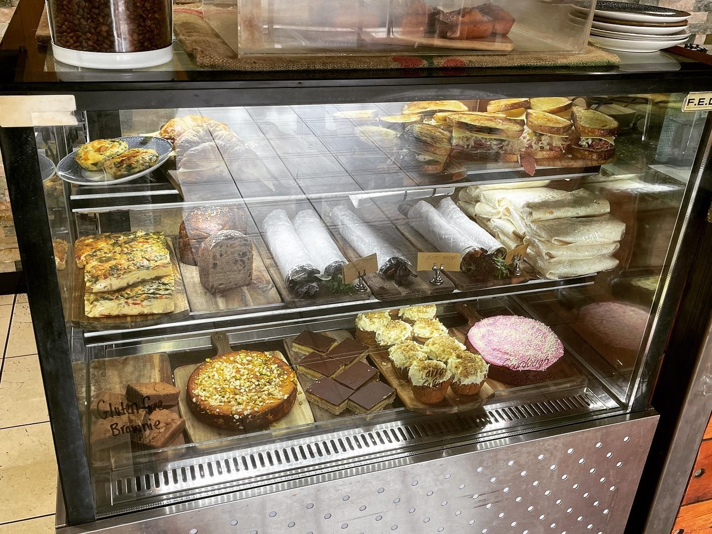 A glass display case filled with a variety of desserts.