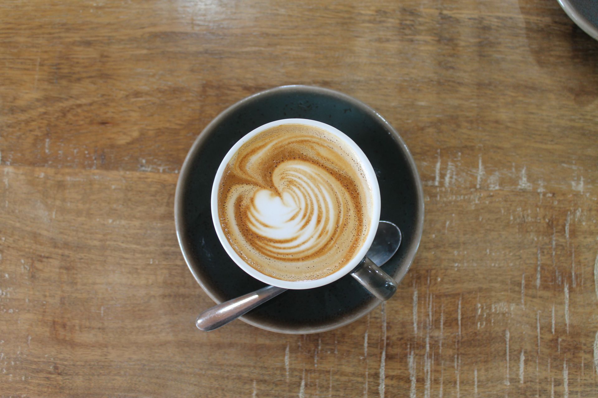 Two Coffee Handles With Nats Coffee Logo In-between On A Wooden Table — Nat’s Coffee in Lismore, NSW