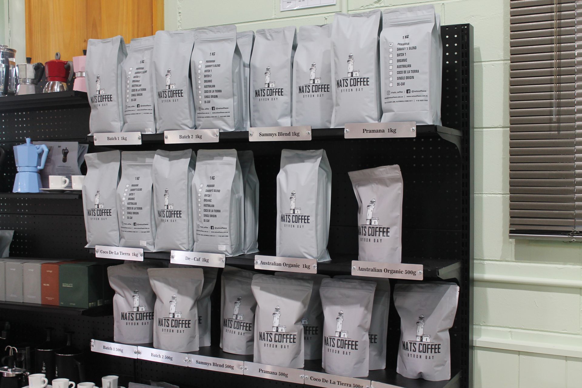 A man is standing in front of a machine in a dark room — Nat’s Coffee in Byron Bay, NSW