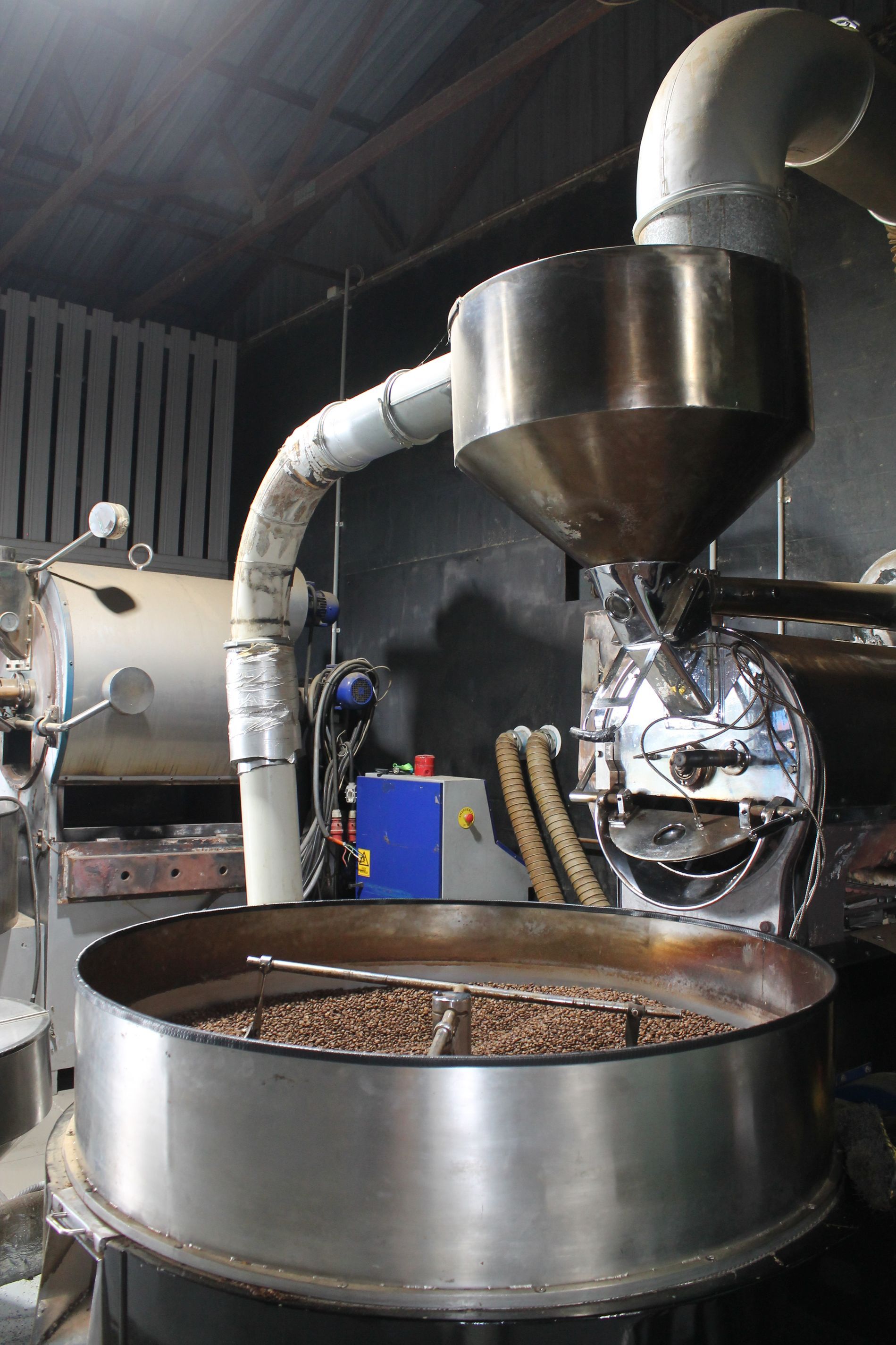 A machine is roasting coffee beans in a warehouse.