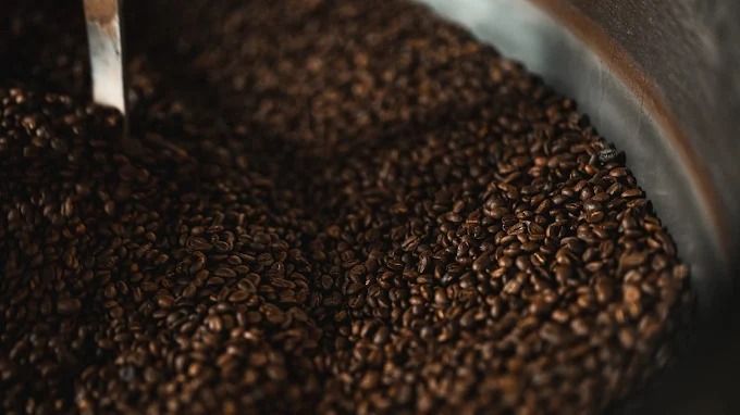 A large metal container filled with coffee beans