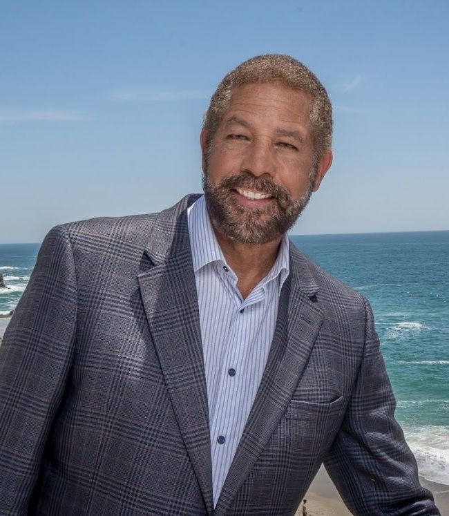 A man with a mustache is wearing a suit and tie