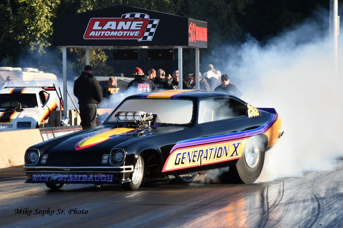 A black car with generation x written on the side is doing a burnout