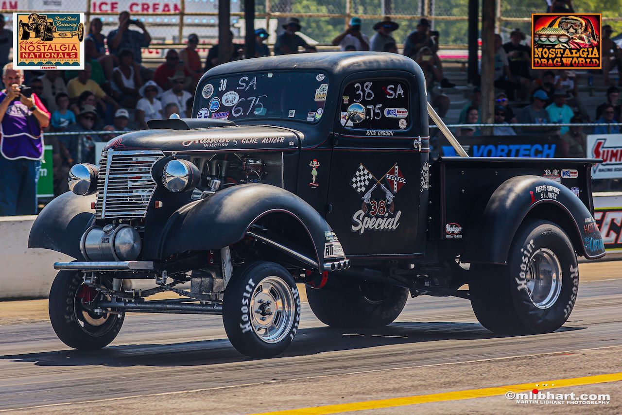 A black truck is driving down a race track.