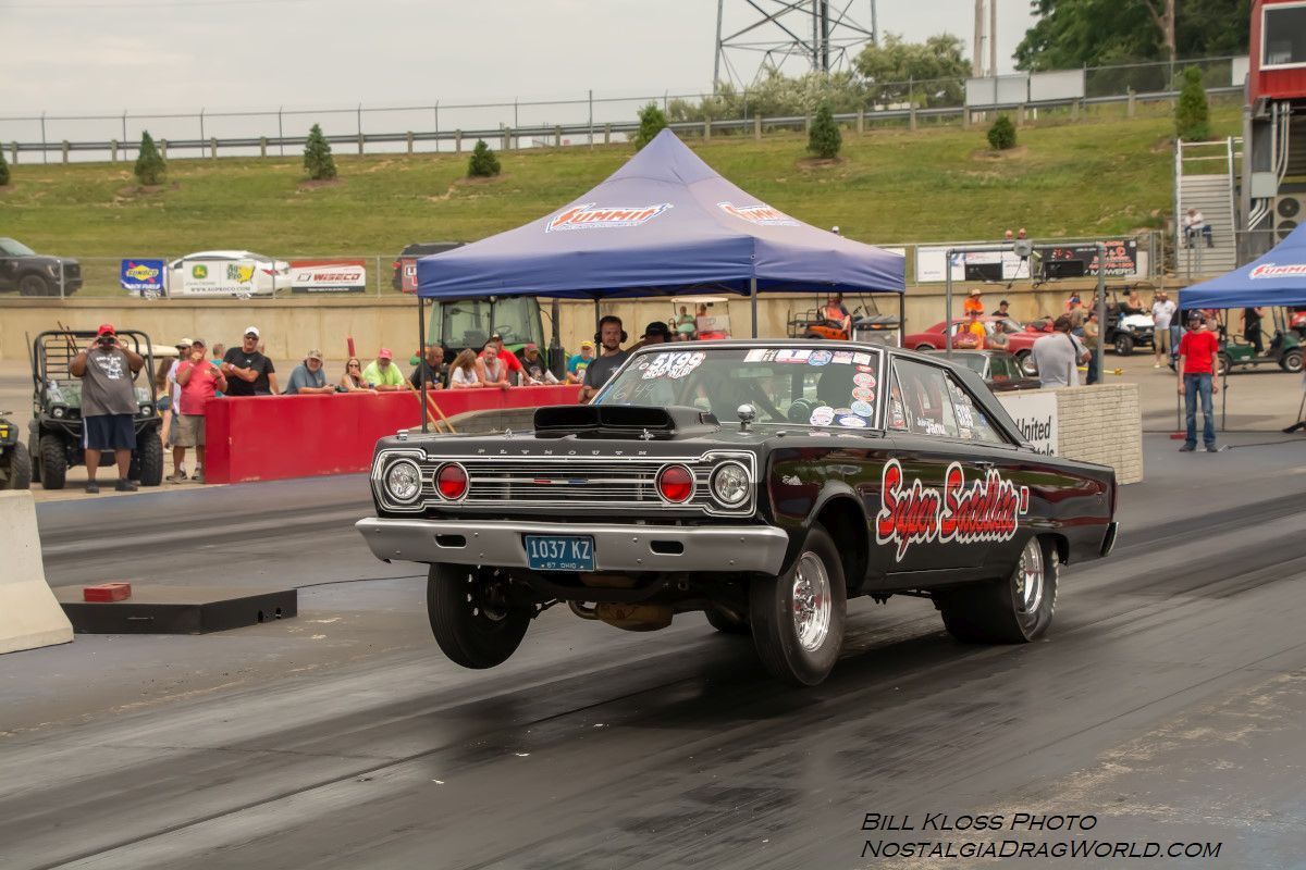 A black car is driving down a race track.
