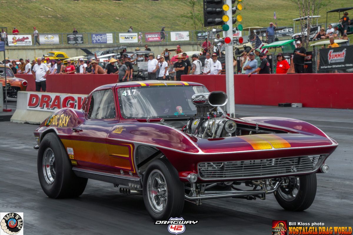 A purple drag car is on a race track