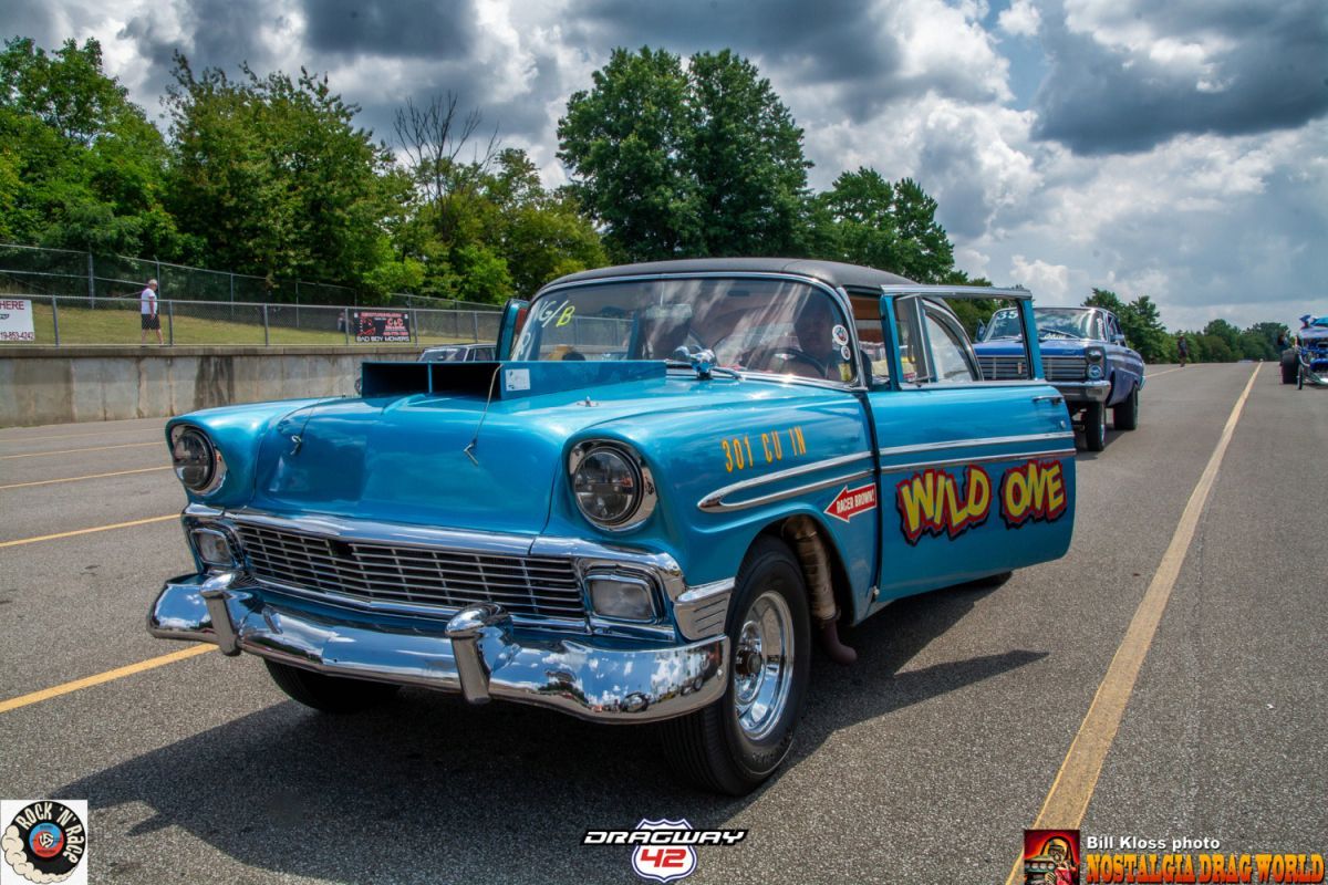 A blue car with the word wild one on the side is parked in a parking lot.