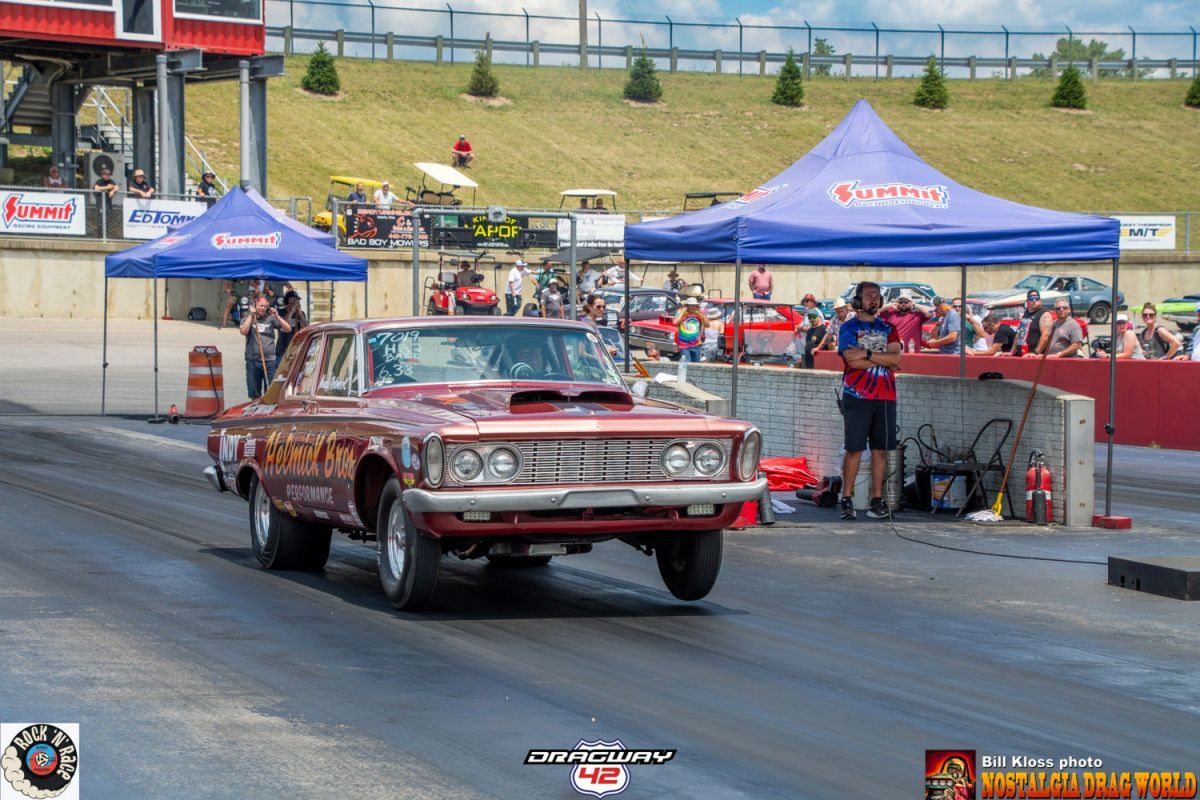 A red car is driving down a race track.