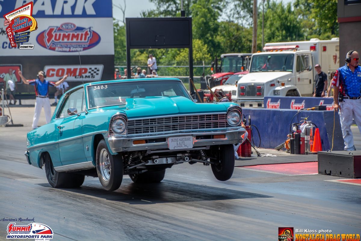 A blue car is driving down a race track.