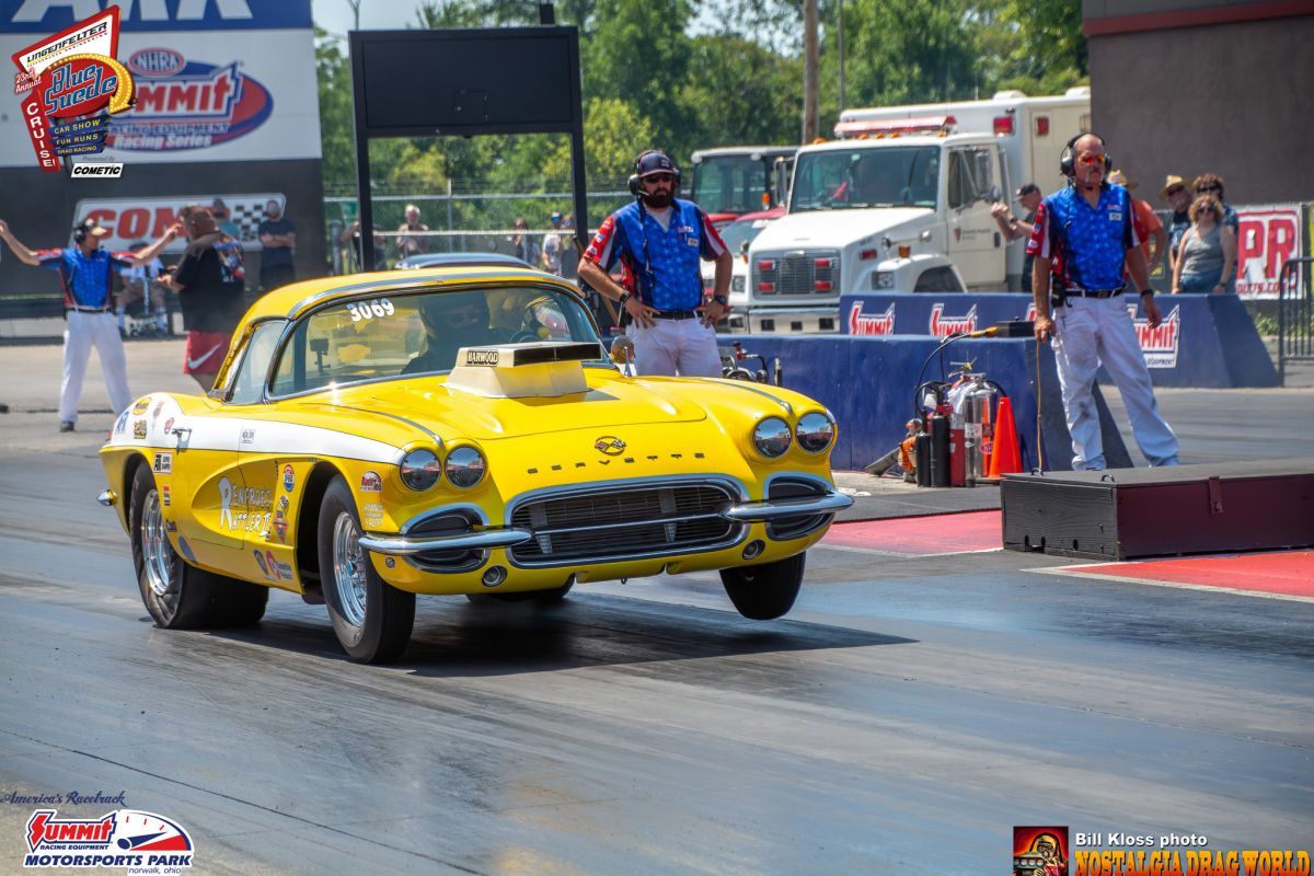 A yellow corvette is driving down a race track
