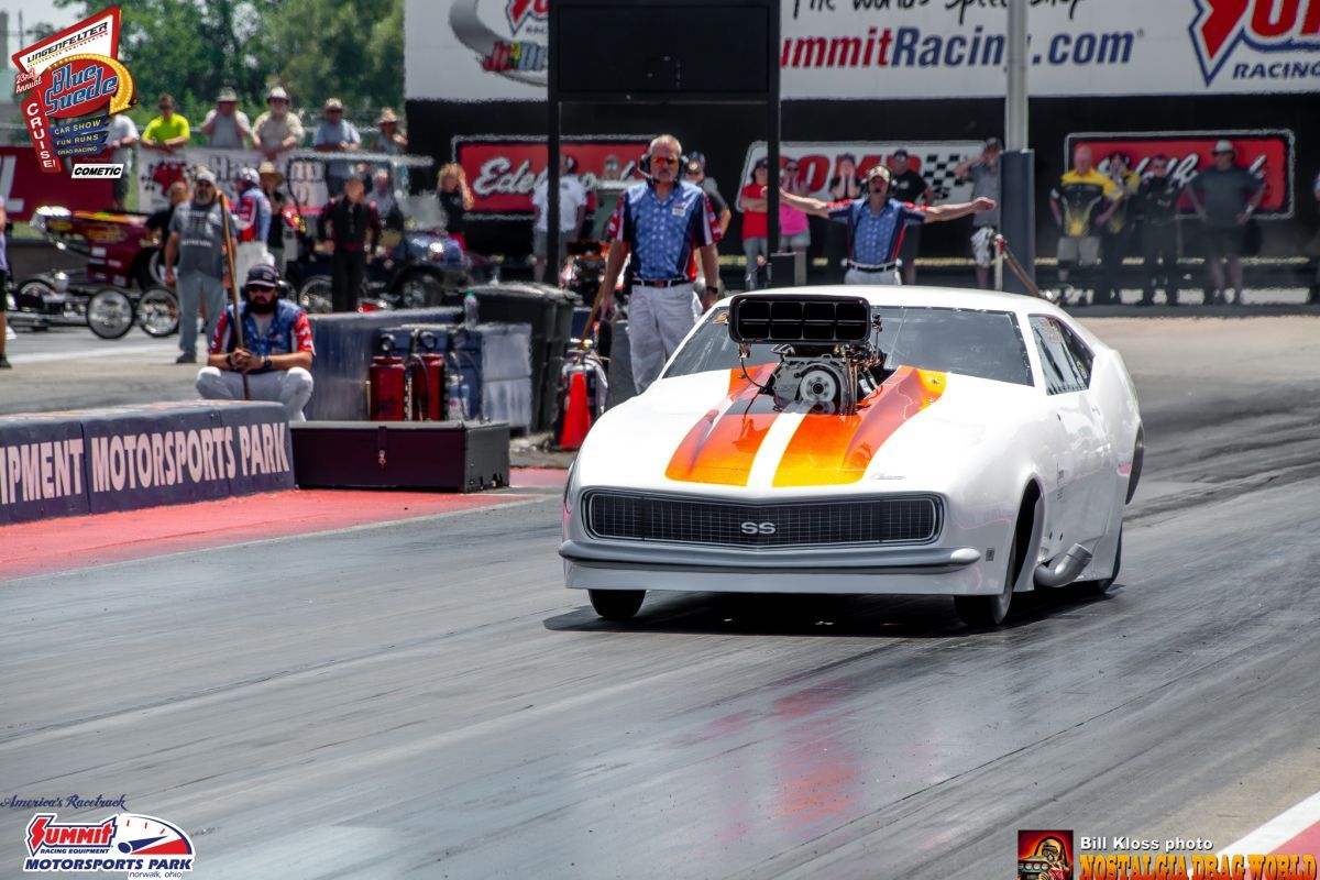 A race car is on a track with a sign that says summitracing.com