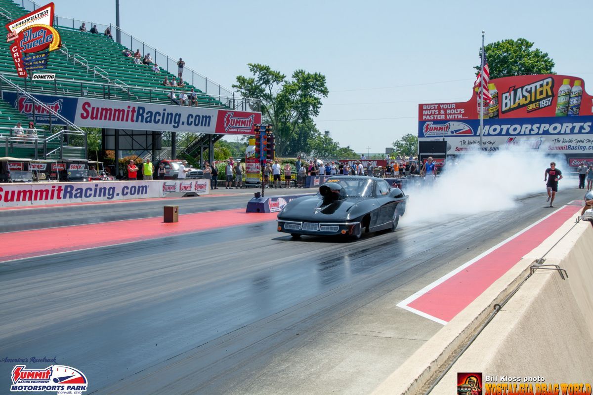 A car is doing a burnout on a race track sponsored by summitracing.com