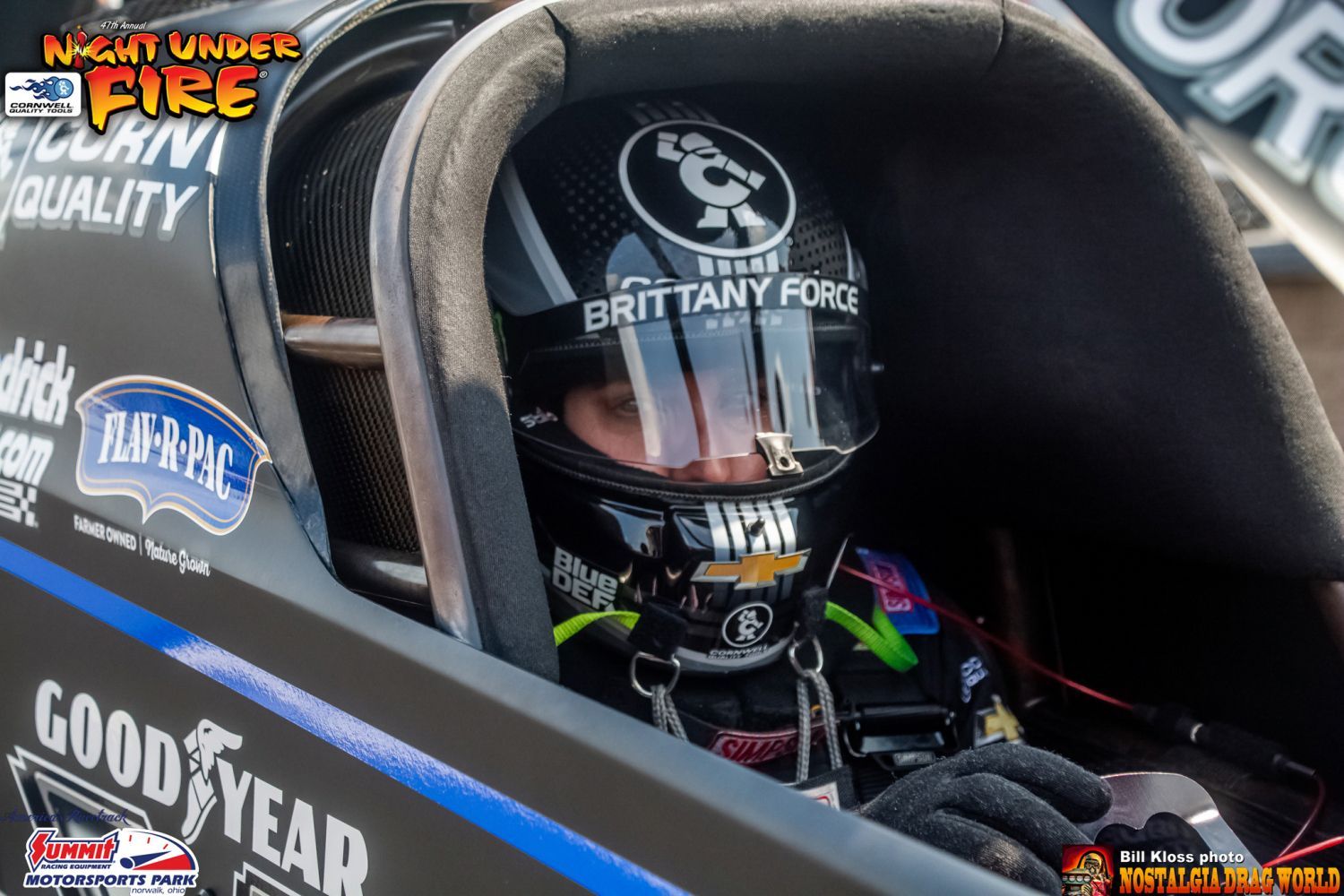 A person wearing a helmet is sitting in a race car.