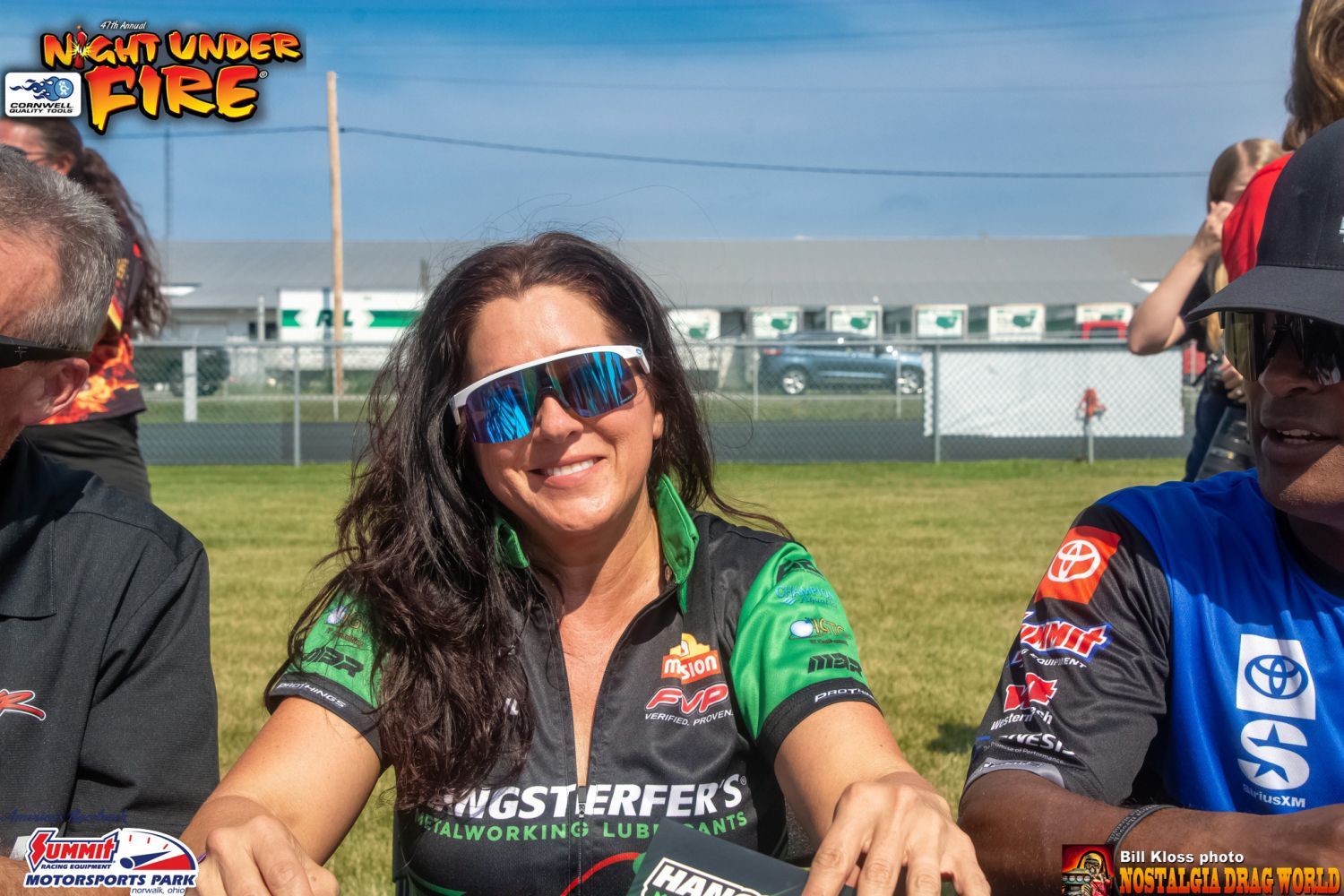 A woman wearing sunglasses and a shirt that says night under fire