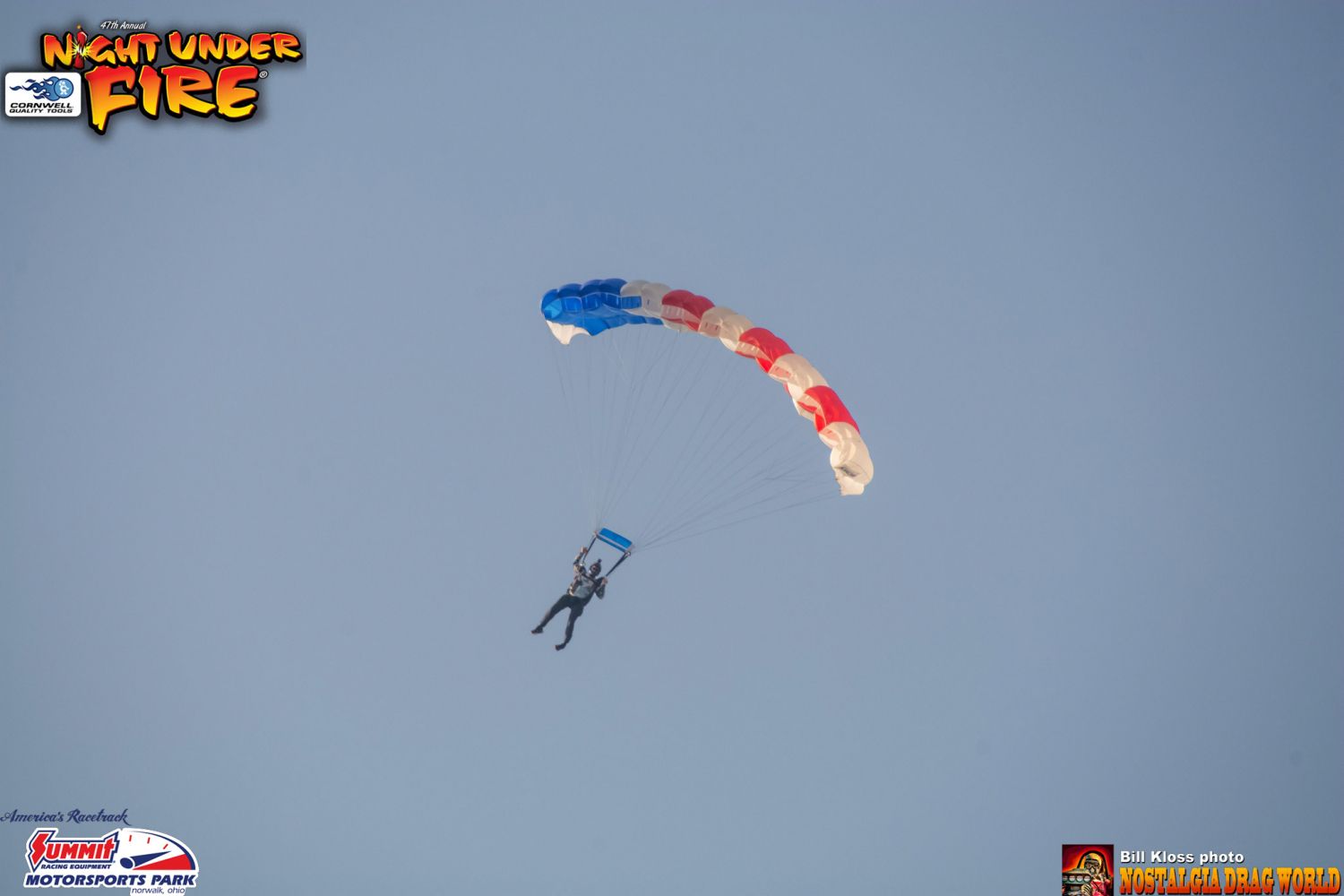 A man is parachuting in the sky with night under fire written on the bottom