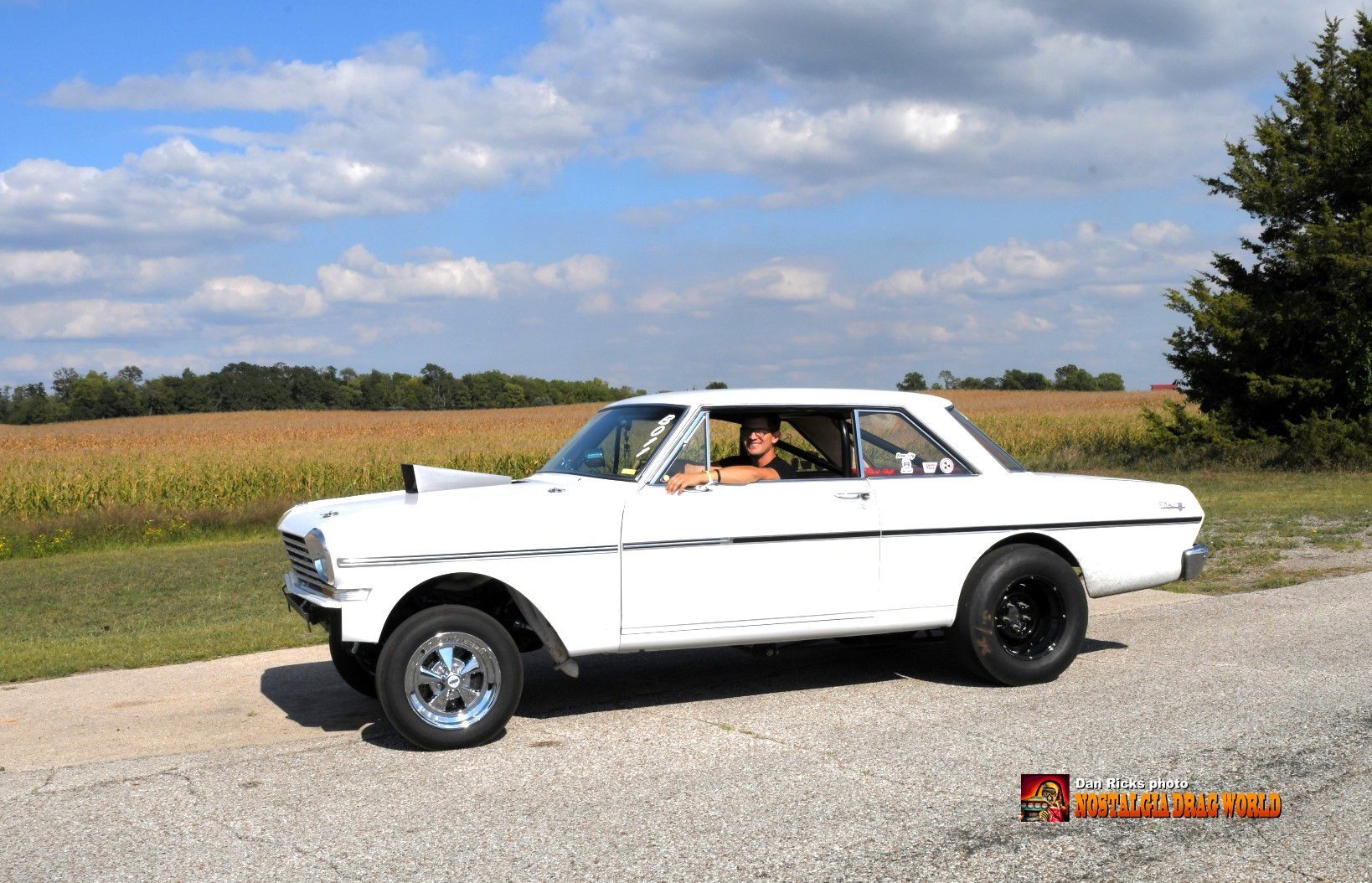 A white car is parked on the side of the road