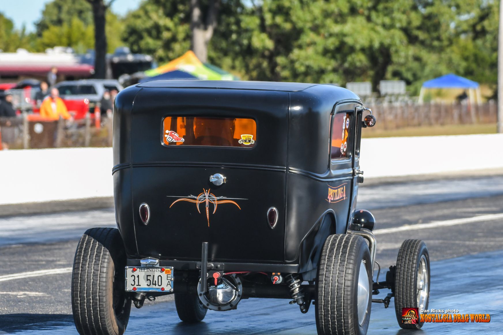 A black car is driving down a race track.