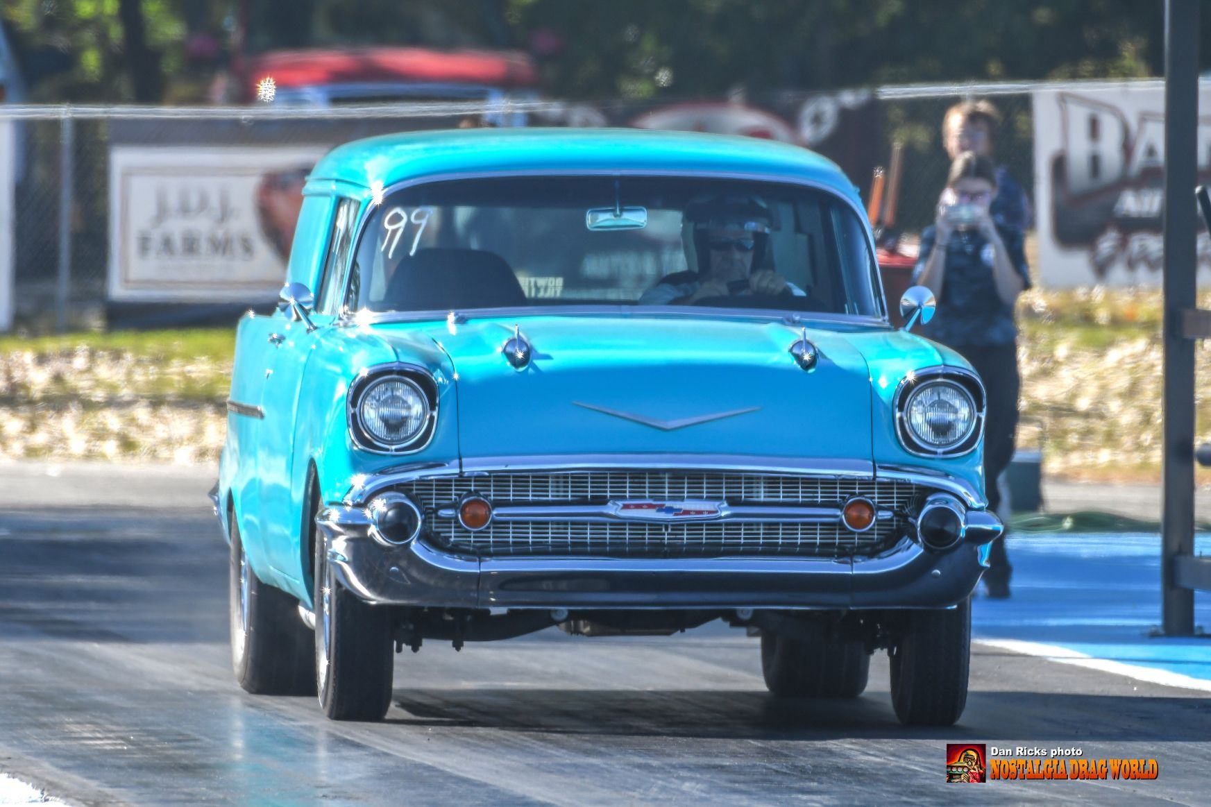 A blue car is driving down a race track.