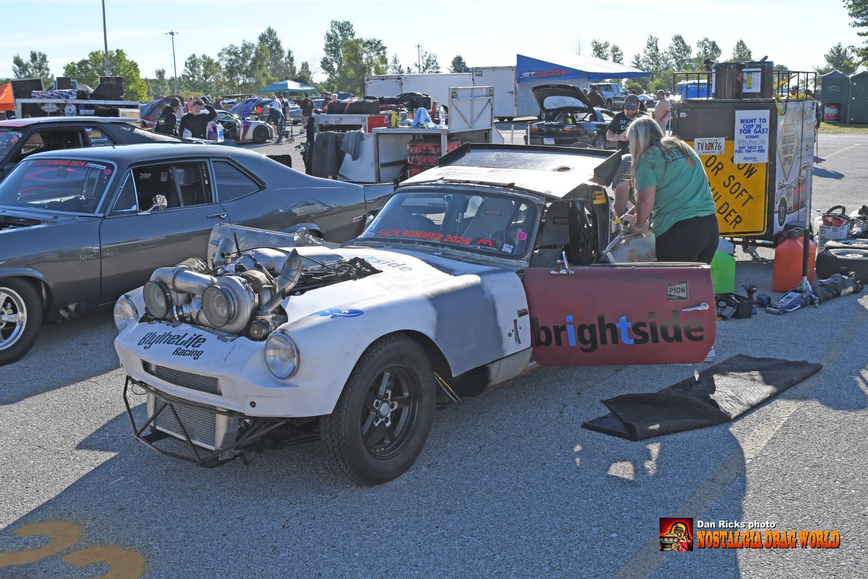 A white car with a red door that says bright blue
