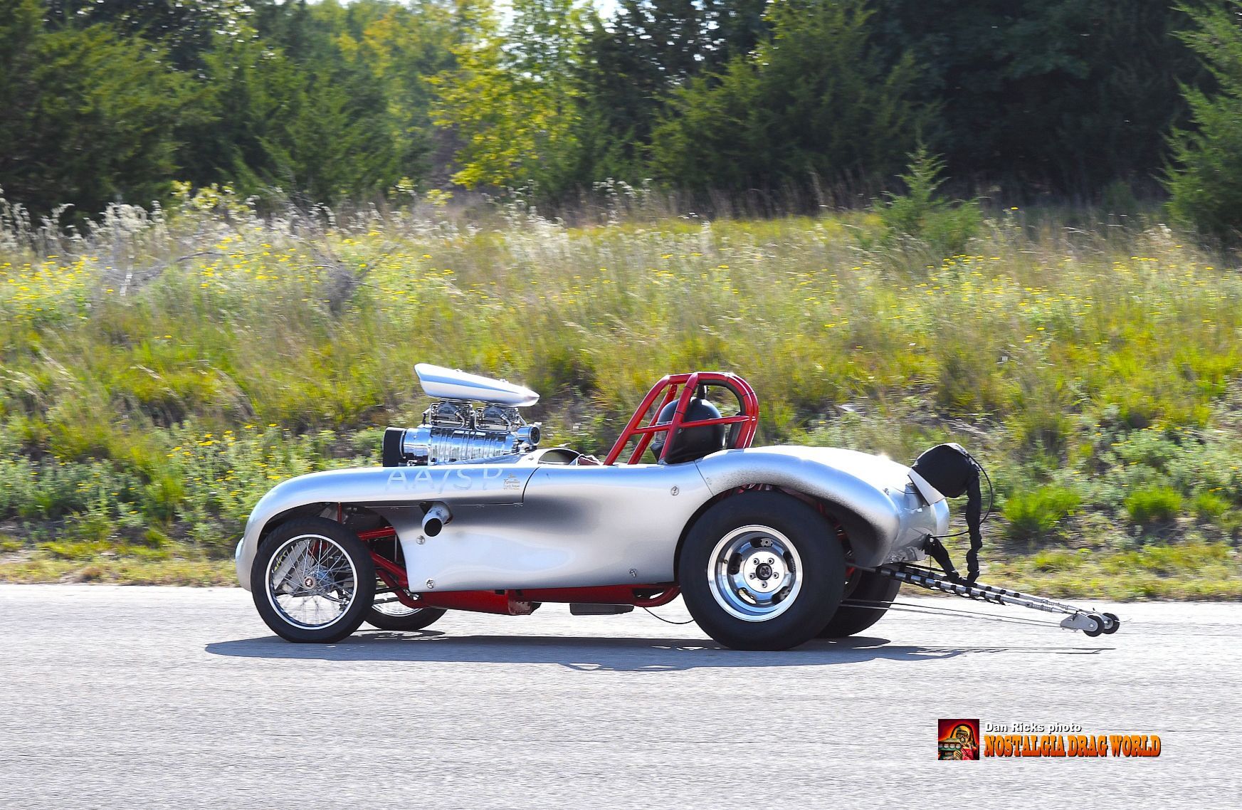 A silver car is parked on the side of the road