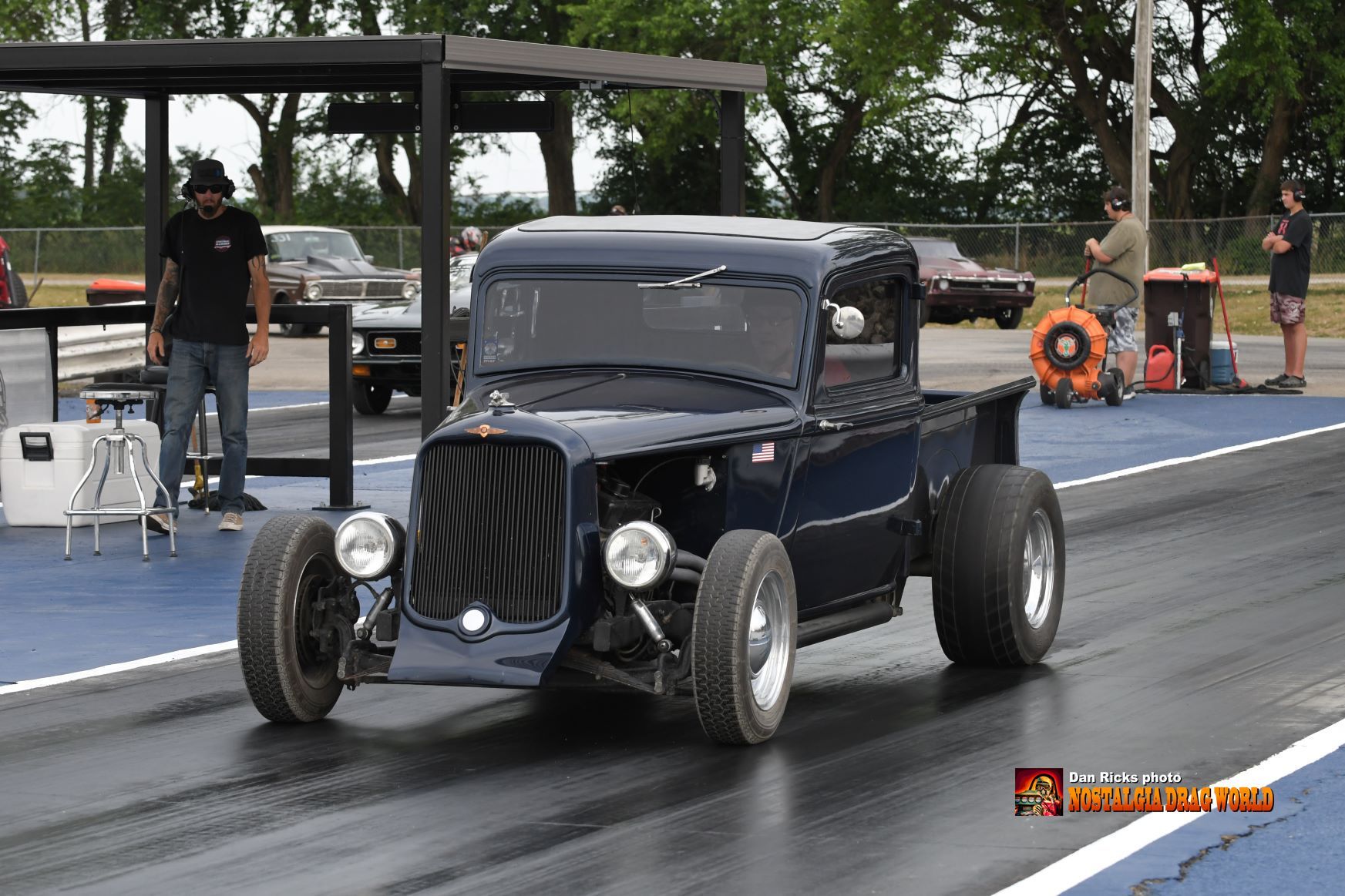 A black truck is driving down a race track