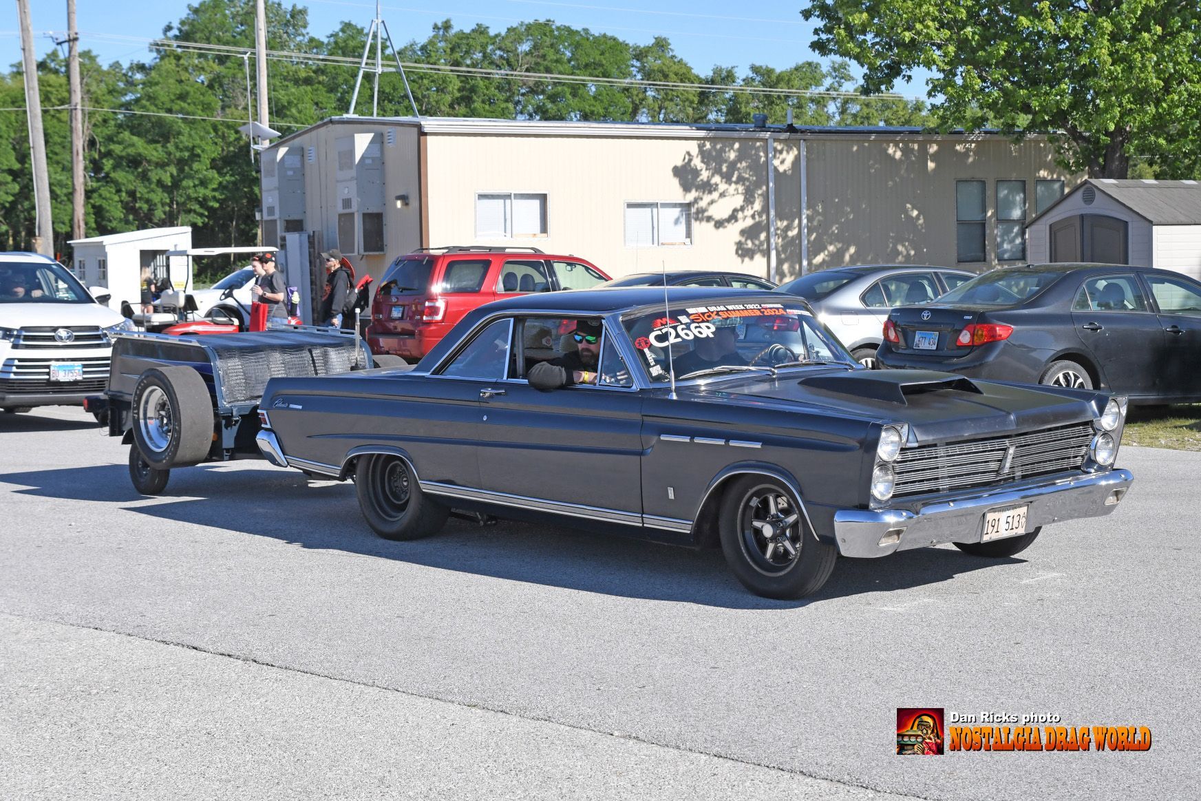 A car with a trailer attached to it is parked on the side of the road