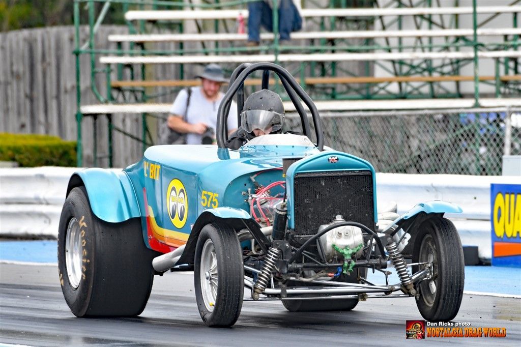 A blue race car is driving down a race track.