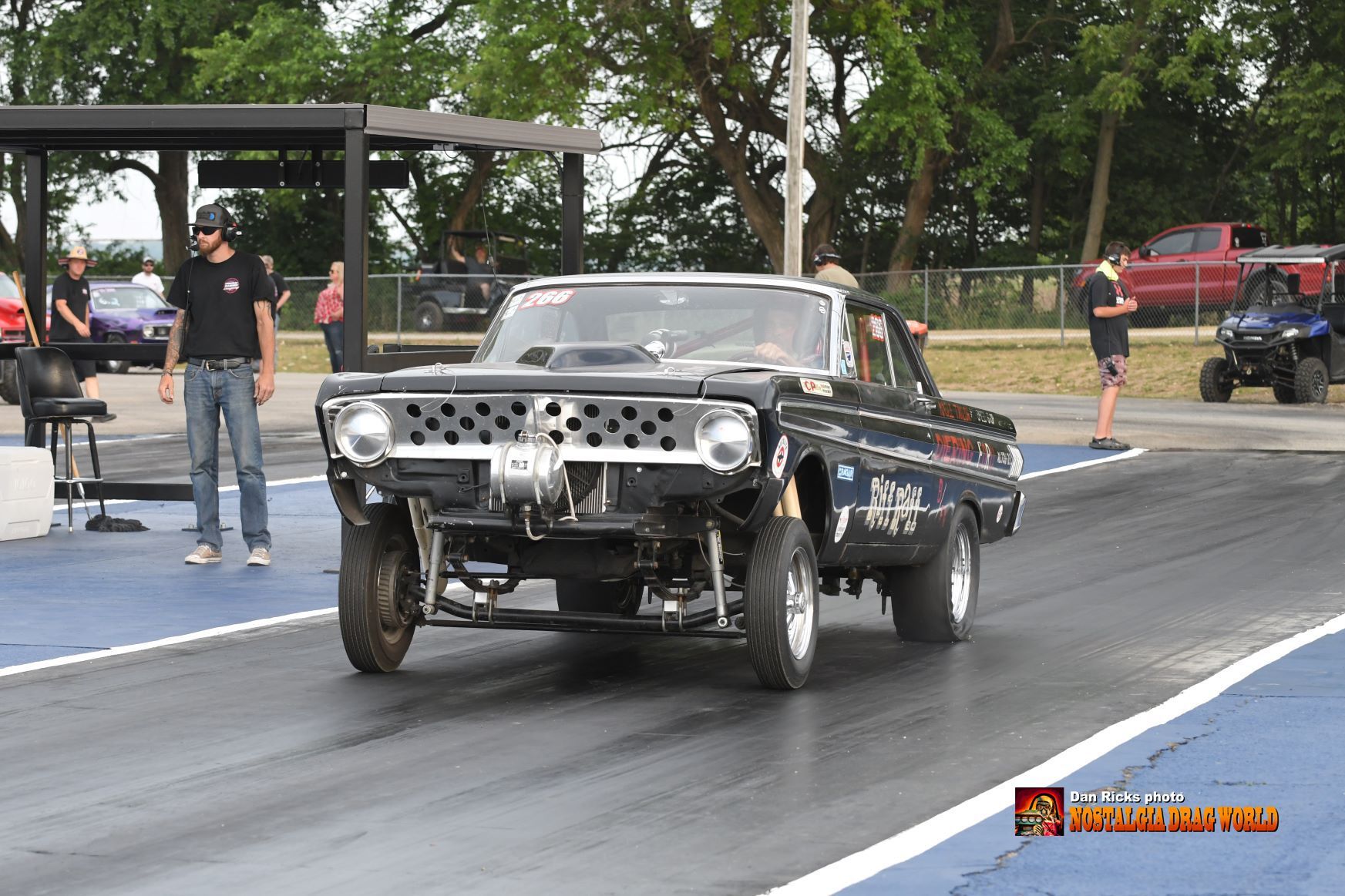 A black car is driving down a race track.