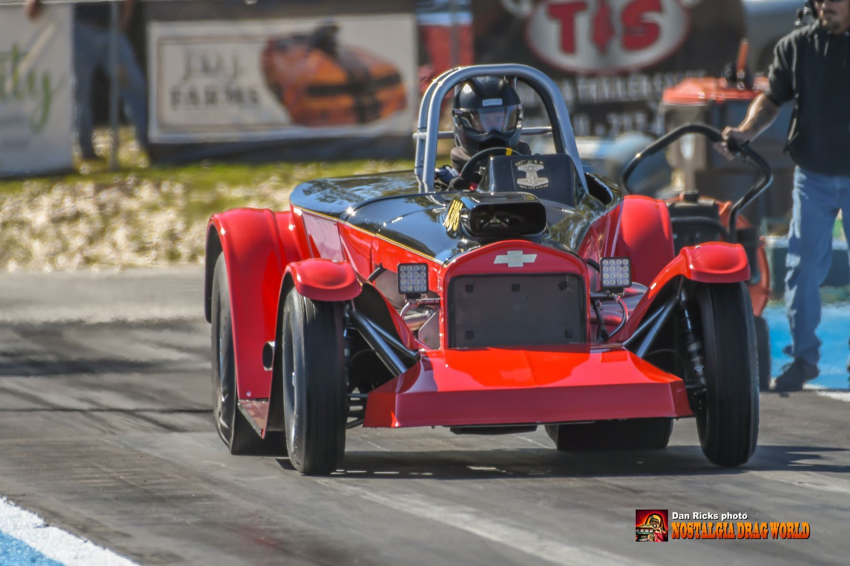 A red car is driving down a race track.