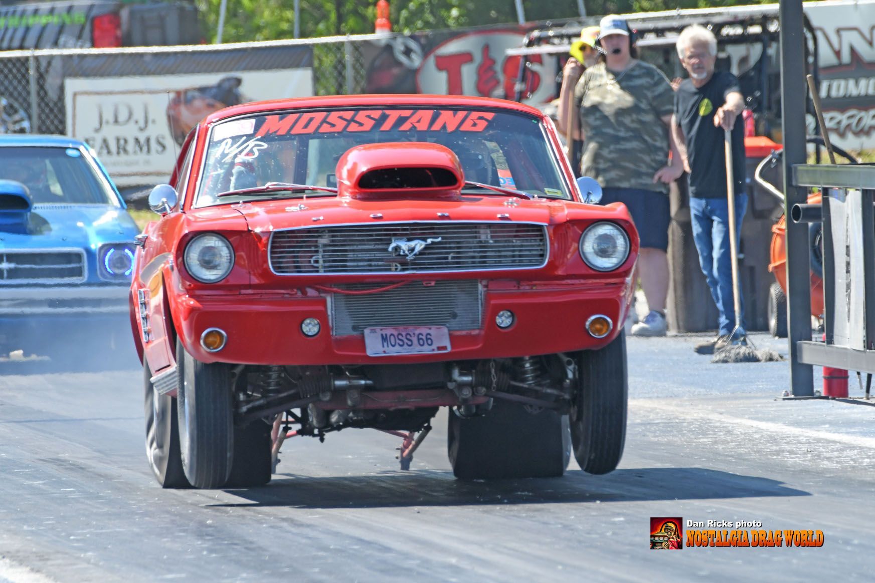 A red mustang is driving down a race track