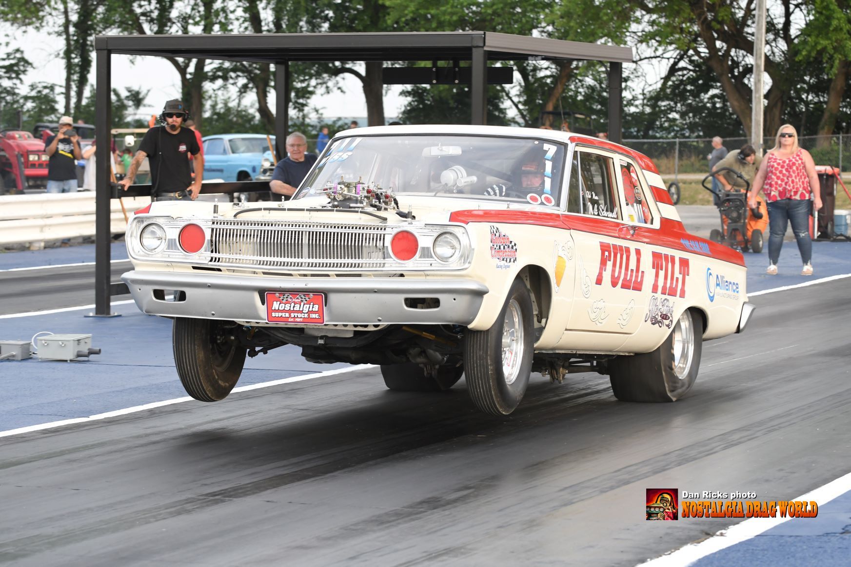 A white and red car is driving down a race track.