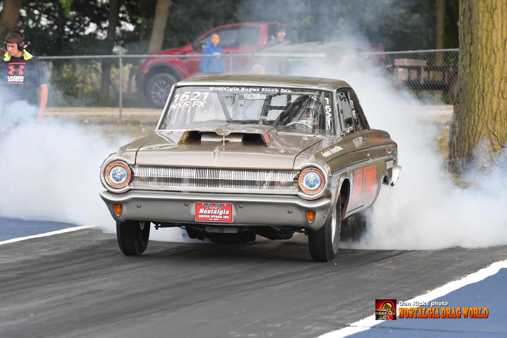 A car is doing a burnout on a race track.