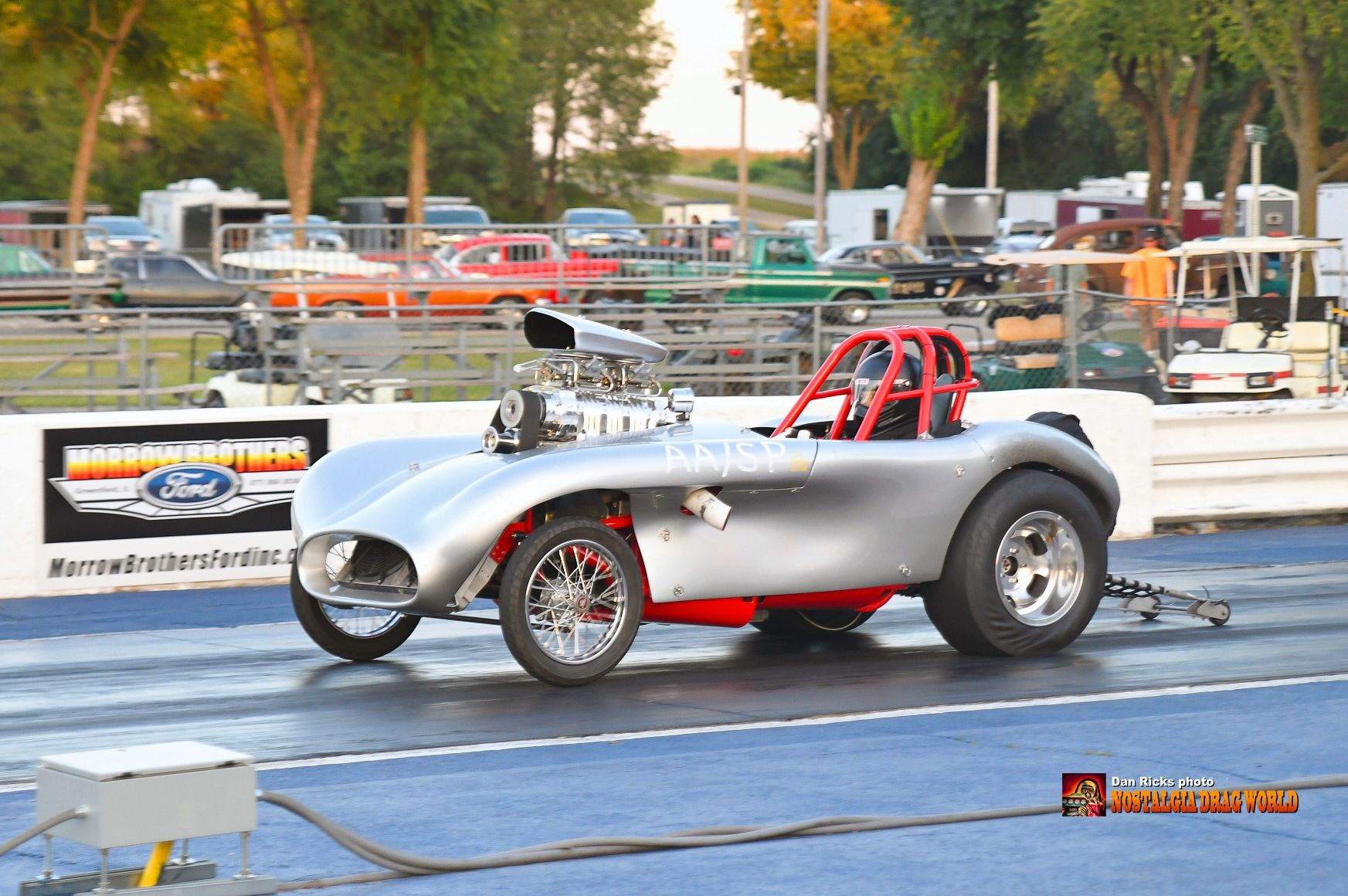 A silver car with a red seat is on a race track