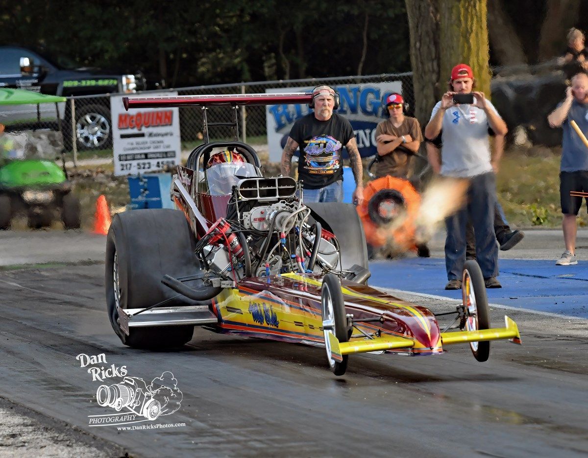 A man is taking a picture of a race car on a track