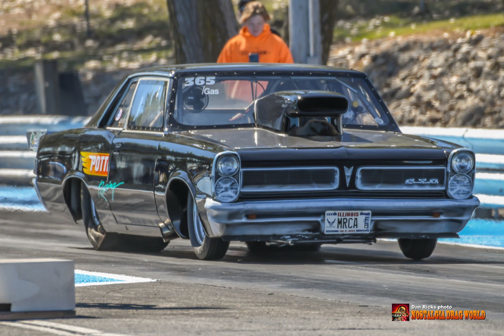 A black car is driving down a race track.