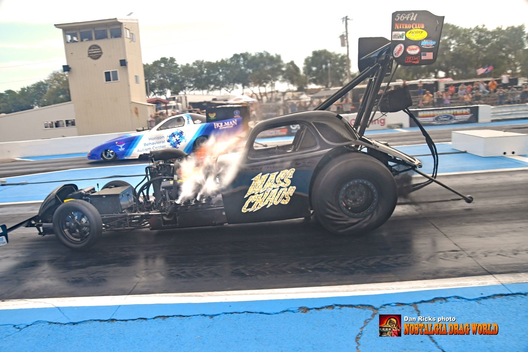 A drag race car is being towed by another car on a track