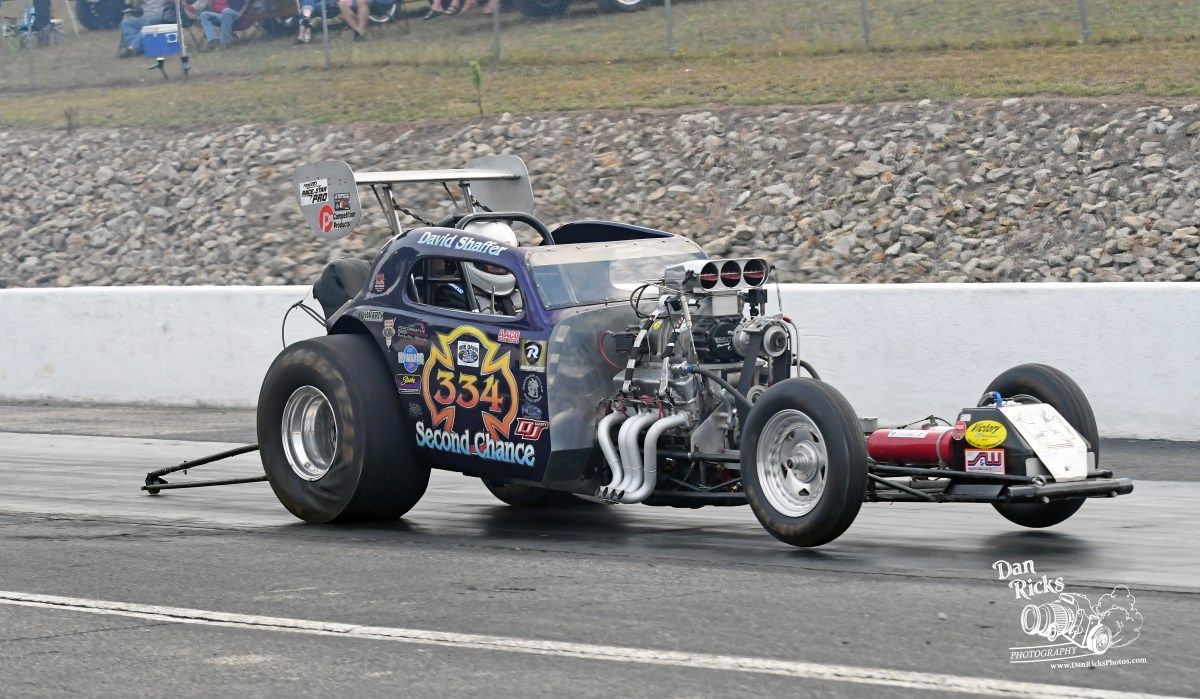 A purple race car is driving down a race track.