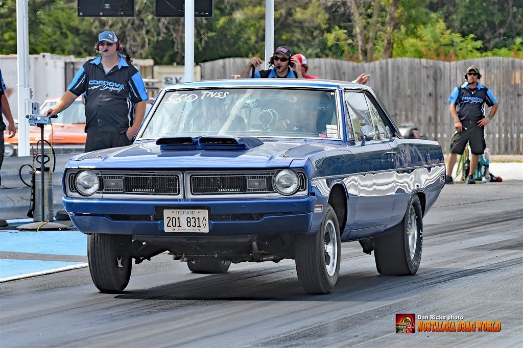 A blue dodge charger is driving down a race track.