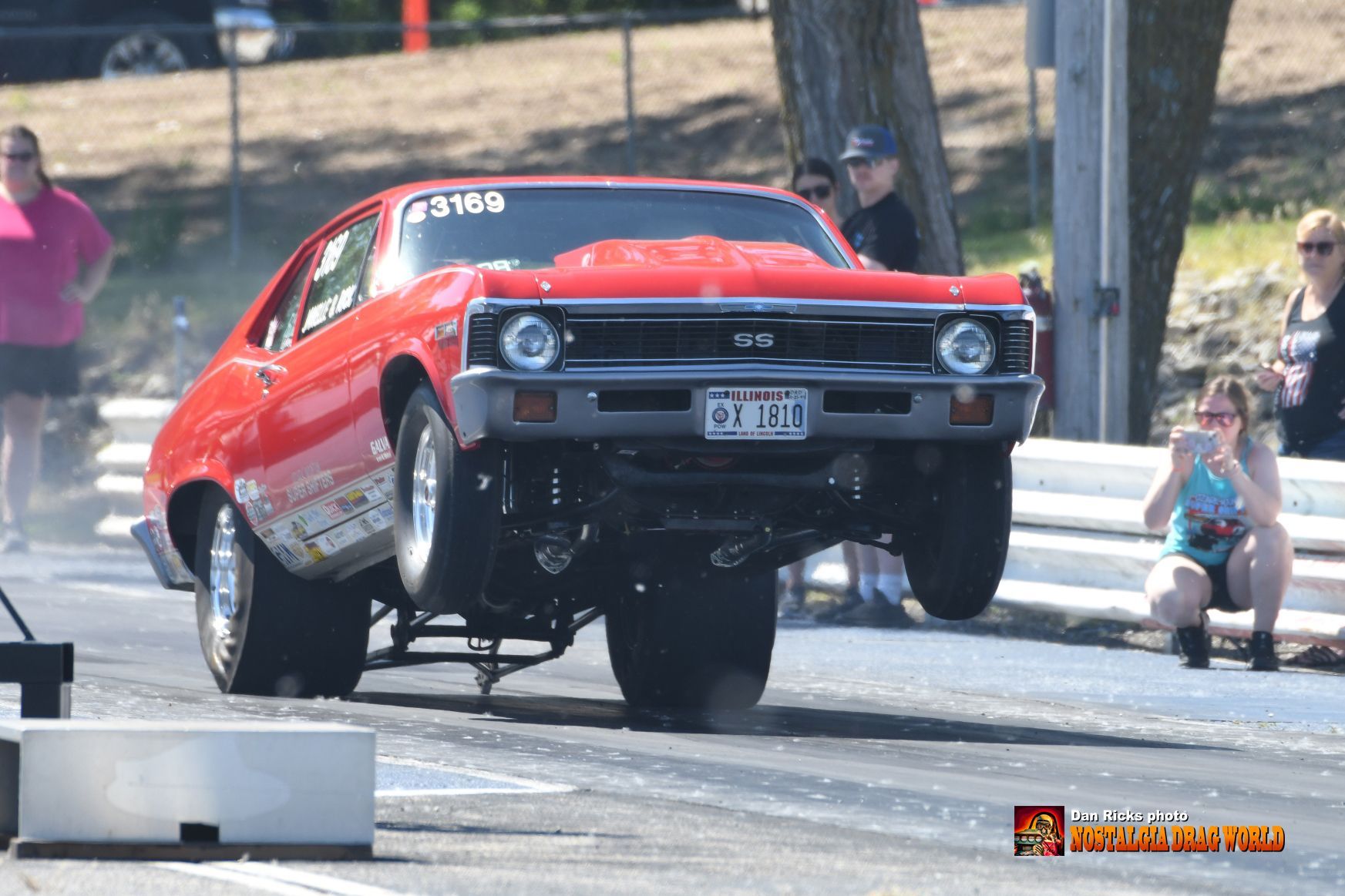 A red car is doing a trick on a race track.
