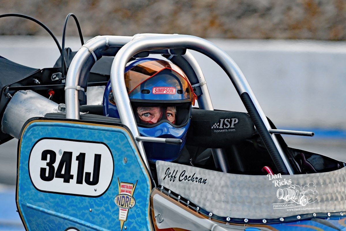 A man is sitting in a race car with the number 341j on the side.