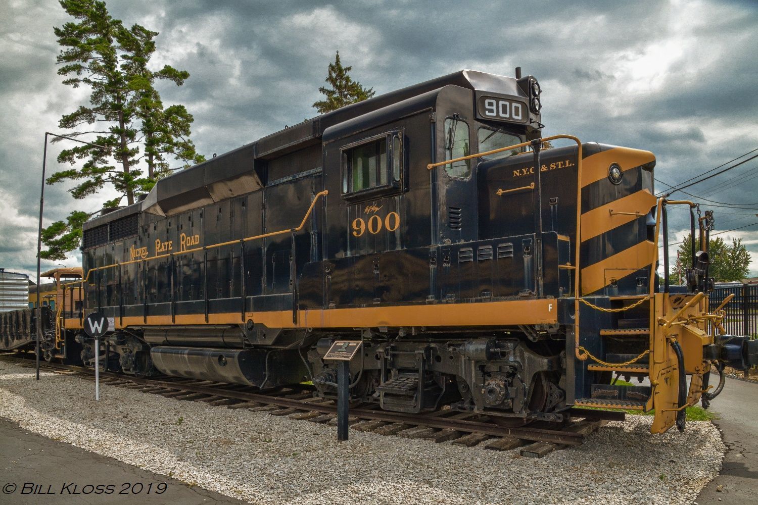 A black and yellow train engine is on display on the tracks.