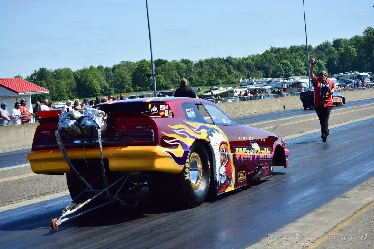 A red and yellow race car with flames on the side is on a race track.