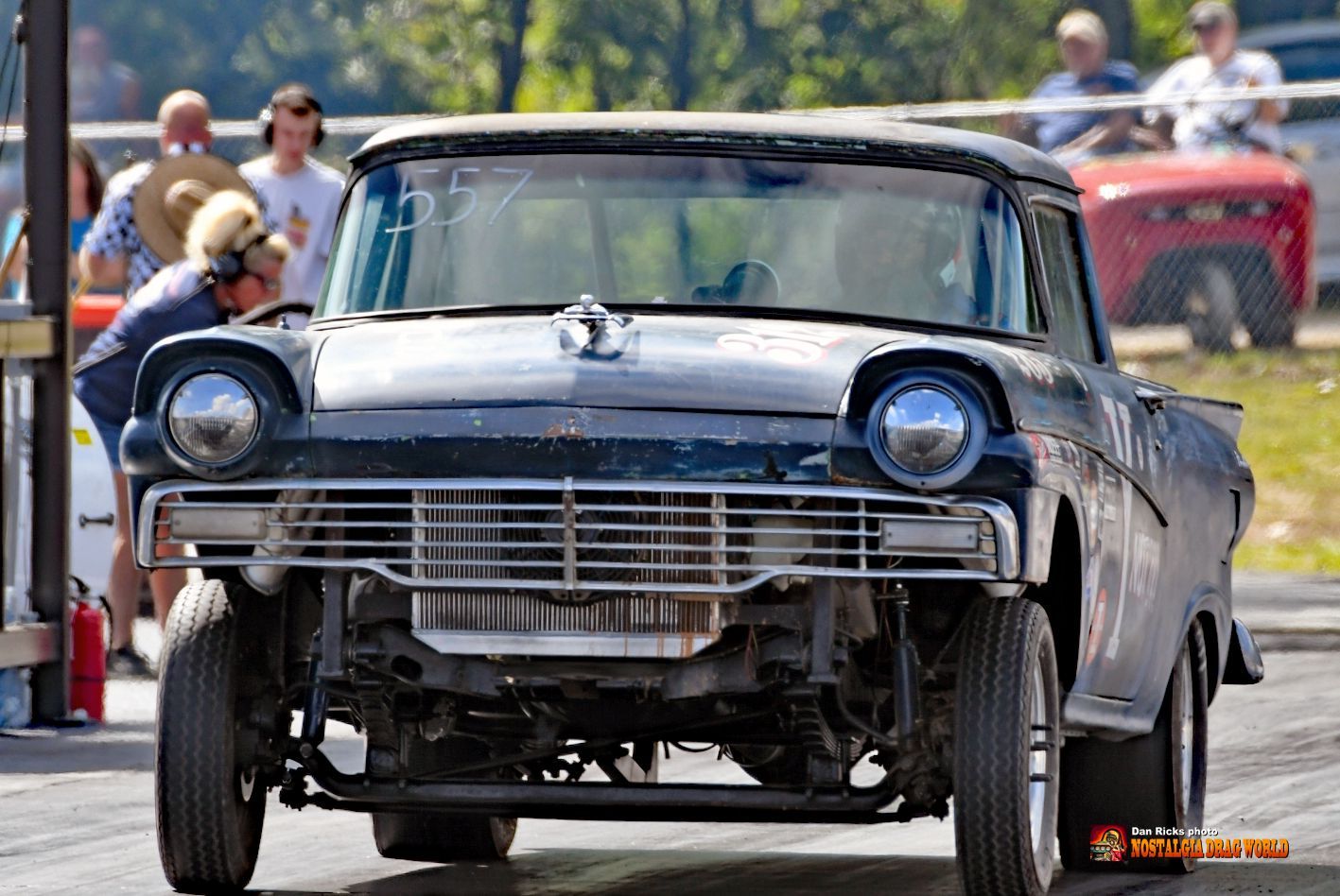 An old car is parked on the side of the road.